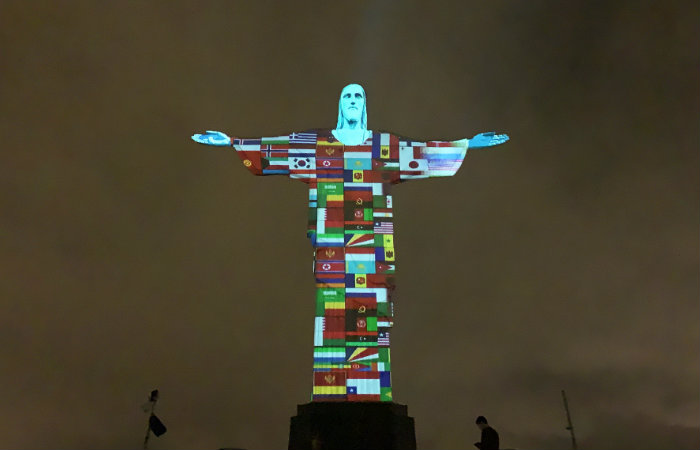 Cristo Redentor é iluminado com 150 bandeiras de países afetados por coronavírus